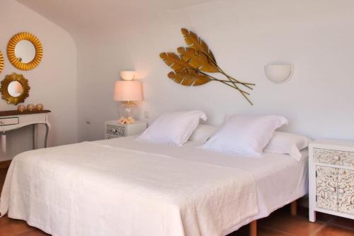 a bedroom with a white bed with a butterfly on the wall at Premium Residence Isabel in Costa Calma