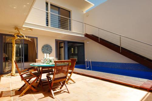 a room with a table and chairs and a staircase at Premium Residence Isabel in Costa Calma