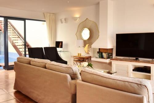 a living room with couches and a flat screen tv at Premium Residence Isabel in Costa Calma