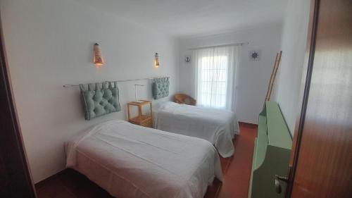 a hotel room with two beds and a window at Vila T2 Algarve piscina privada in Vila Nova De Cacela