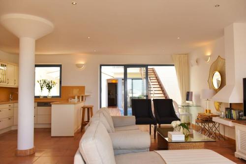 a living room with a white couch and a kitchen at Premium Residence Isabel in Costa Calma