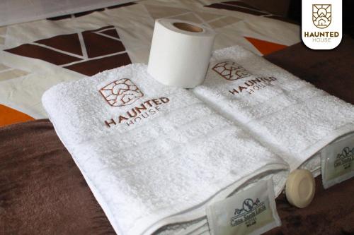 una pila de toallas y un rollo de papel higiénico en Haunted House Casa Vacacional en Baños