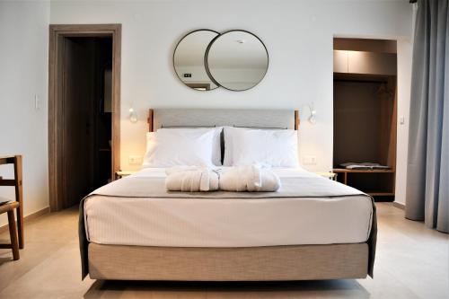 a bedroom with a large bed with a mirror on the wall at La Mer Luxury Apartments in Ierissos