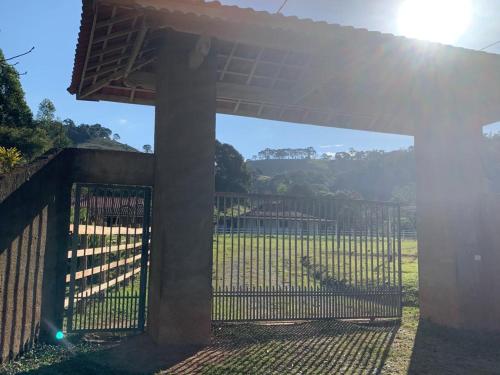 a fence with a gate with the sun behind it at Recanto Bellini's in Barreira