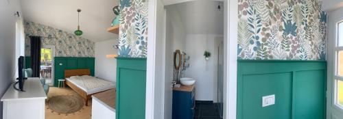 un pasillo con puertas verdes y una habitación con un banco en Backyard Cottage, 