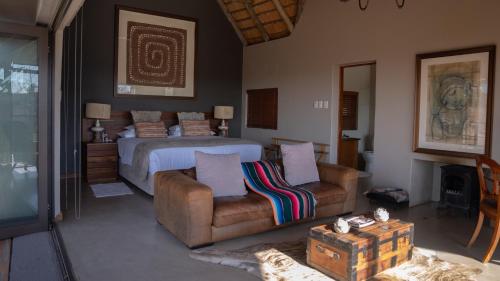 1 dormitorio con 1 cama, 1 sofá y 1 silla en Sibani Lodge, en Krugersdorp