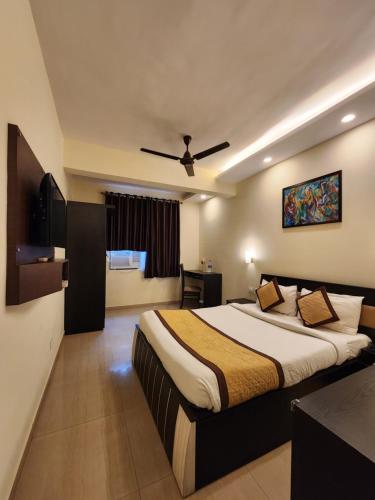 a bedroom with a large bed with a ceiling fan at All Seasons Guest House I Rooms & Dorms in Madgaon