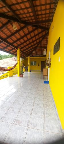 an empty room with a yellow wall and a chair at Casa da Vila - Hospedaria - 3 min do centrinho de Alter in Alter do Chao