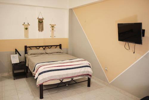 a bedroom with a bed and a flat screen tv at Departamento Orellana 5 in Chetumal