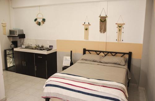 a bedroom with a bed and a kitchen with a sink at Departamento Orellana 5 in Chetumal