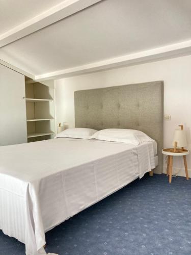 - une chambre avec un grand lit blanc et une table dans l'établissement Lotentik residence, à La Rochelle