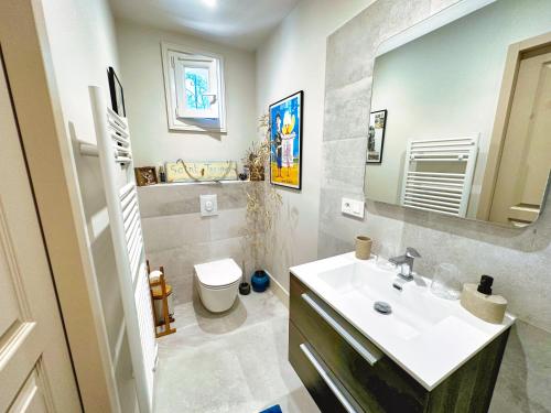 a bathroom with a sink and a toilet and a mirror at Le Repos du Keyrié in Saint-Marc-Jaumegarde