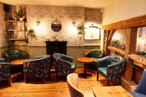 a restaurant with chairs and tables and a fireplace at Three Horseshoes, Bubbenhall in Bubbenhall