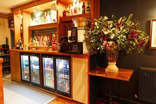 a bar with a vase of flowers on a counter at Three Horseshoes, Bubbenhall in Bubbenhall