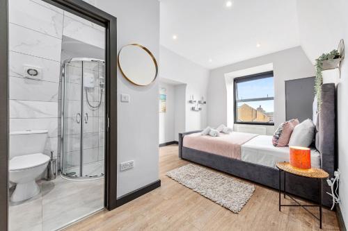 a bedroom with a bed and a shower and a bathroom at Sydenham Stays by Hayes Residency in London