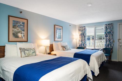 a hotel room with two beds and a window at Stage Run by the Sea in Ogunquit