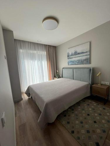 a bedroom with a large bed and a large window at Obelų namai, self check-in, free parking in Klaipėda