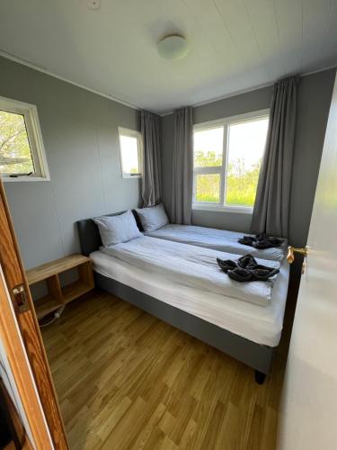 a small bedroom with a bed with a window at Summer house - Fíflholt in Hvolsvöllur