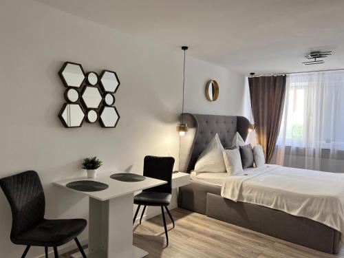 Schlafzimmer mit einem Bett, einem Tisch und Stühlen in der Unterkunft Sophie Flair Apartment in Karlsruhe