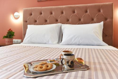 a tray of donuts and a tray of coffee on a bed at Villa Val-Gio in Ermoupoli
