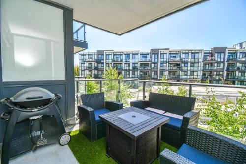 a patio with a grill and a table and chairs at PET FRIENDLY CONDOS at FRIDAY HARBOUR in Innisfil