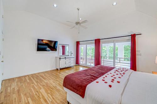 a bedroom with a large bed with red curtains at Tranquil Bays Estate in Hampton Bays