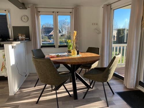 a dining room with a wooden table and chairs at Villetta Verde in Asten-Heusden