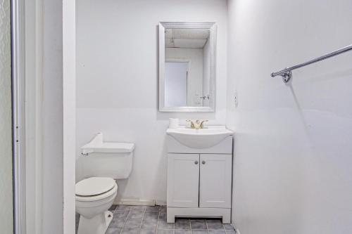 a bathroom with a toilet and a sink and a mirror at Tranquil Bays Estate in Hampton Bays