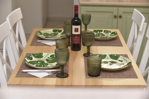 a table with a bottle of wine and glasses on it at Villa Val-Gio in Ermoupoli