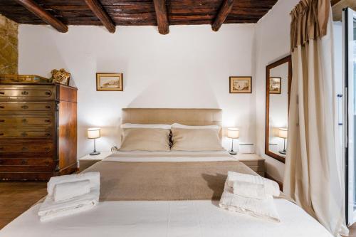 een slaapkamer met een groot bed met 2 lampen en een dressoir bij La storia in Napels