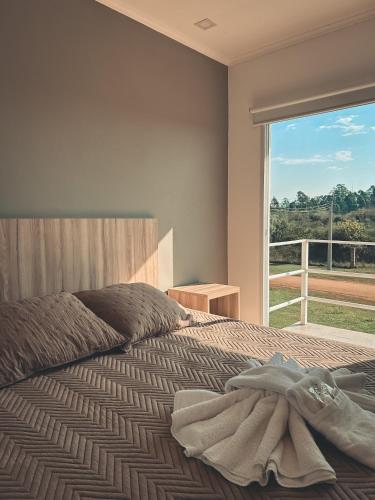 a bedroom with a bed with a large window at Buenos Vientos Complejo - Termas Chajarí in Chajarí
