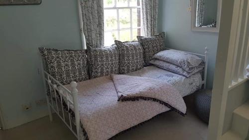 um quarto com uma cama com almofadas e uma janela em Millstream House em Winchester