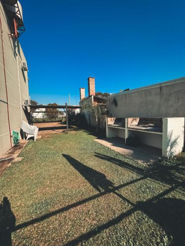 a grassy yard with a bench next to a building at Buenos Vientos Complejo - Termas Chajarí in Chajarí