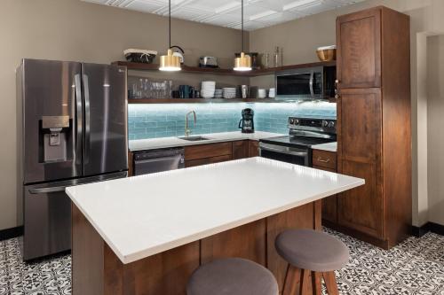 a kitchen with a refrigerator and a white counter top at The Highlander Hotel, Ascend Hotel Collection in Iowa City