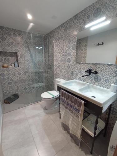 a bathroom with a sink and a shower and a toilet at Cal Masot del Gaià in Aiguamurcia