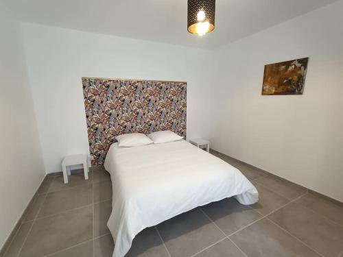 une chambre avec un lit blanc et un mur dans l'établissement Maison de village en Provence, à Saint-Geniès-de-Comolas