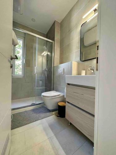 een badkamer met een toilet, een wastafel en een douche bij Villa Ida in Punat