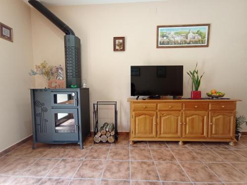 a living room with a television and a wood stove at Cal Masot del Gaià in Aiguamurcia