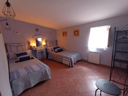 a bedroom with two beds and a window at Cal Masot del Gaià in Aiguamurcia