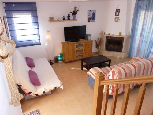 a living room with a couch and a television at Relajante casa Climatizada Parking privado y Cerca del Mar in Miami Platja