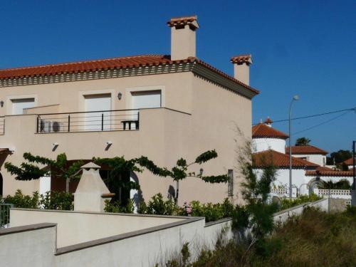 a white building with a balcony on top of it at Relajante casa Climatizada Parking privado y Cerca del Mar in Miami Platja