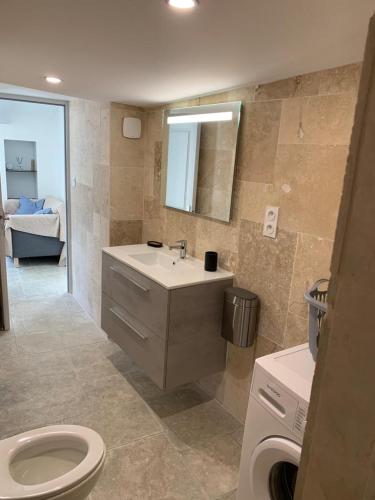 a bathroom with a sink and a toilet and a couch at Terre de Lumière 3 in Nyons