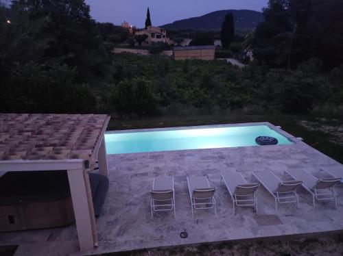 a pool with chairs and a table and a house at Terre de Lumière 3 in Nyons