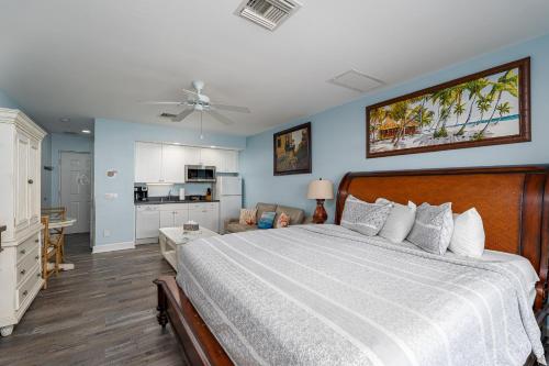 a bedroom with a large bed and a kitchen at Harbour House stunning Studio in Fort Myers Beach