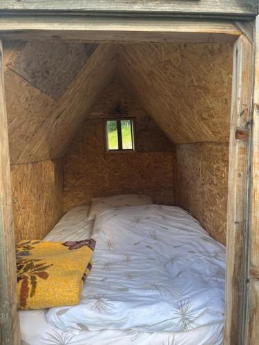 a bed in a wooden room with a window at Katun Lanista-Kolibe Bogavac in Mojkovac