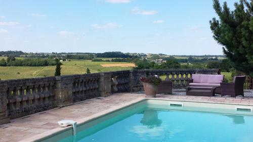 - une piscine avec un canapé et une chaise à côté d'une clôture dans l'établissement Chateau de la Grave, à Bourg