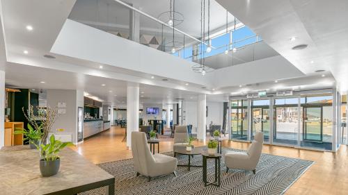 an office with a lobby with chairs and tables at Holiday Inn Express Leigh - Sports Village by IHG in Leigh