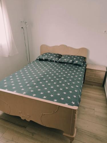 Una cama con una manta verde con estrellas blancas. en ΚΛΕΟΠΑΤΡΑ en Sfendámion