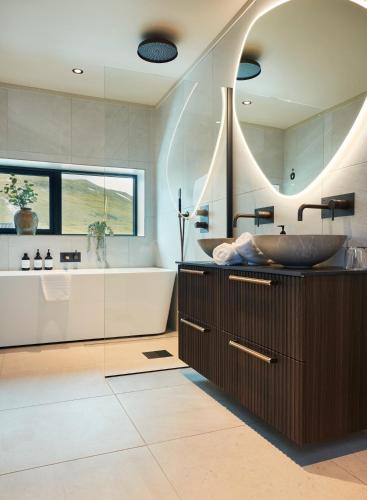 a bathroom with a tub and a sink and a tub and shower at Brimi Fjellstugu in Fluguhaug