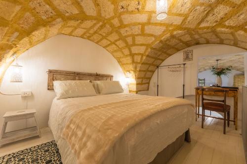 a bedroom with a bed and a desk in a room at Casa Taila in Ruffano
